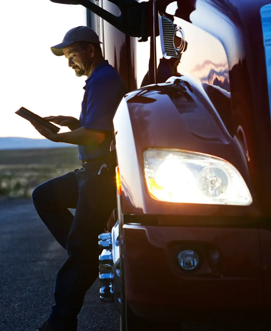 A truck driver reviewing his log in the cab